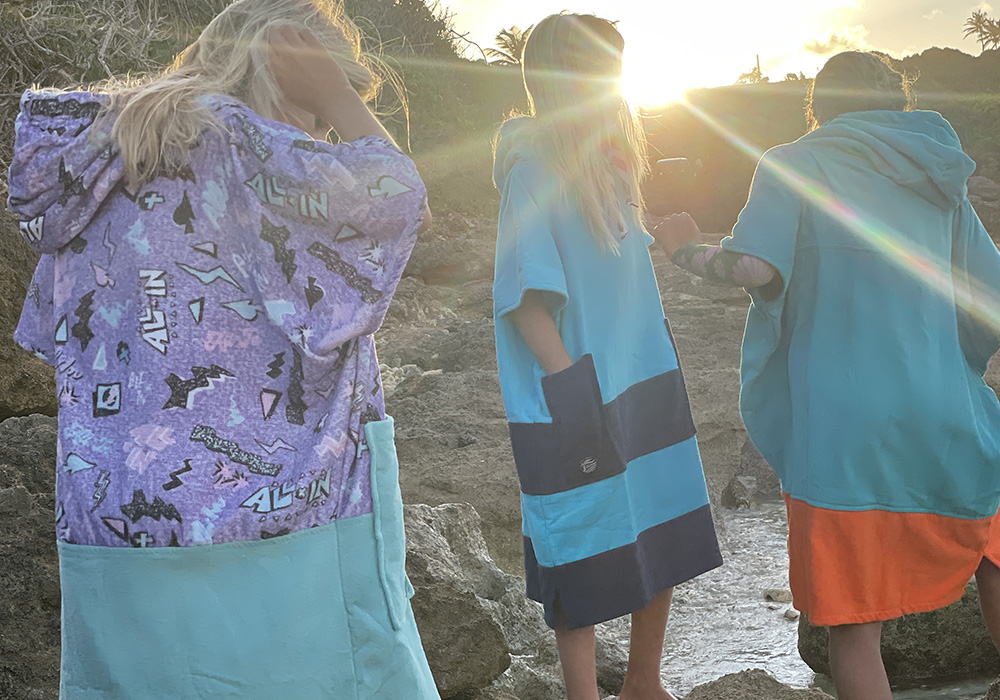 Pro surfer girls wearing all-in ponchos