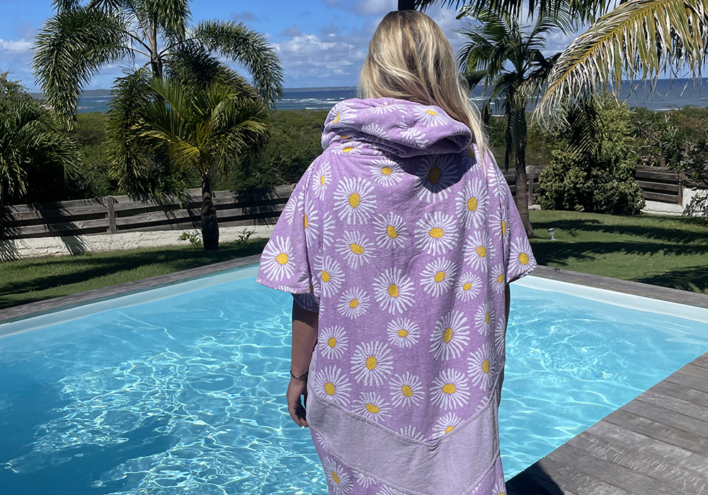 A woman with a poncho at the pool